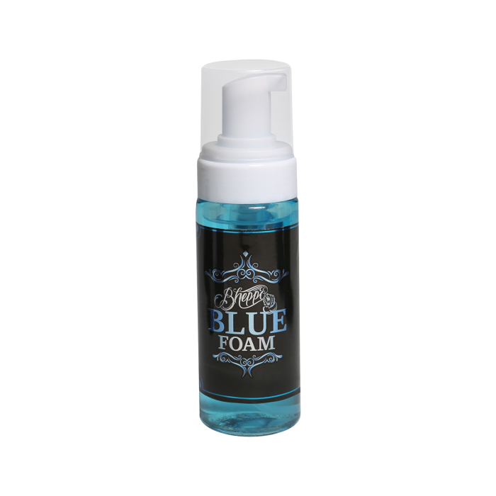 Un flacon en plastique transparent avec un distributeur à pompe moussant blanc, rempli de liquide bleu et étiqueté « Bheppo Aftercare - Mousse bleue 150 ml » sur une étiquette décorative noire et bleue.