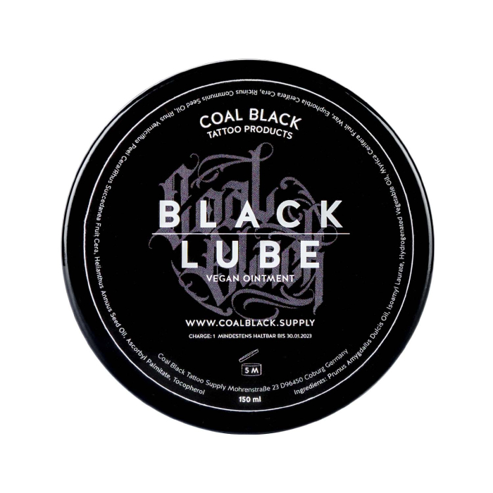 Un récipient rond noir étiqueté « Coal Black - Pommade de tatouage végane Black Lube 120 g », vu d’en haut, avec un texte blanc et gris détaillant le produit et l’entreprise.
